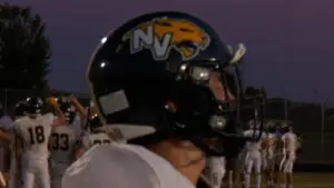 Neuqua Valley runs past Metea valley as Neuqua football player warms up.
