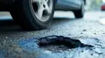 Close up of pothole in road with car tire for story on DuPage road improvement plan