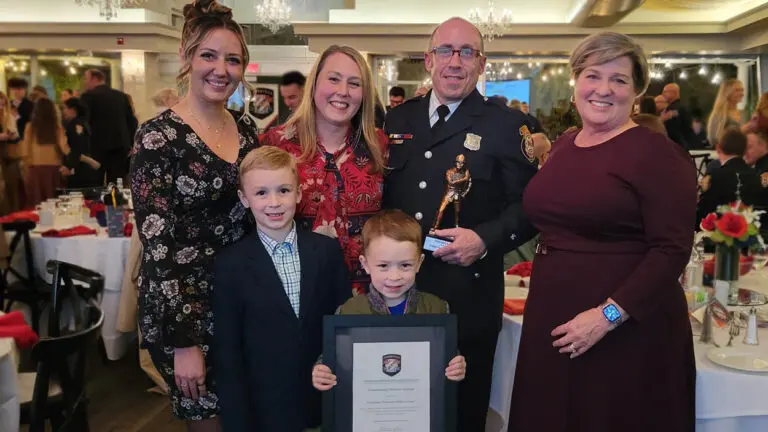 Firefighter/Paramedic Philip Carmody poses with the George Winckler award with this family.