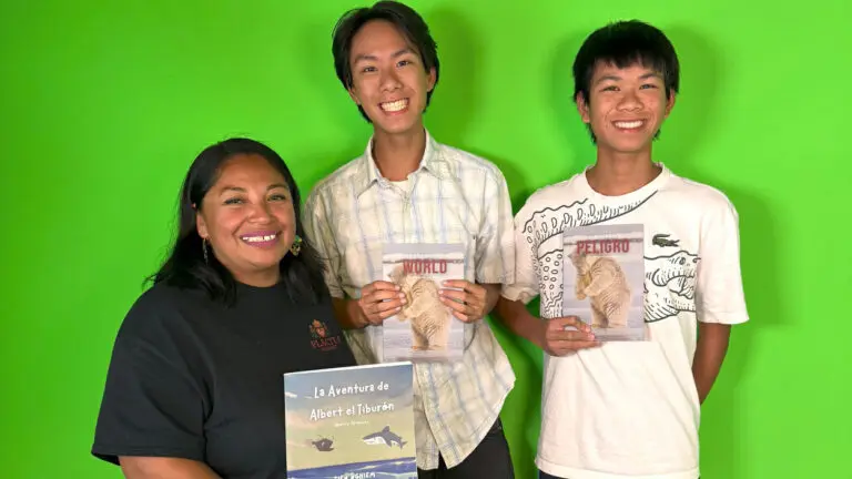 Kendall Tai Nghiem and Kinsler Tien Nghiem, along with a female, hold up books.