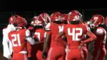 Homewood-Flossmoor football clinches play as they huddle on the field.