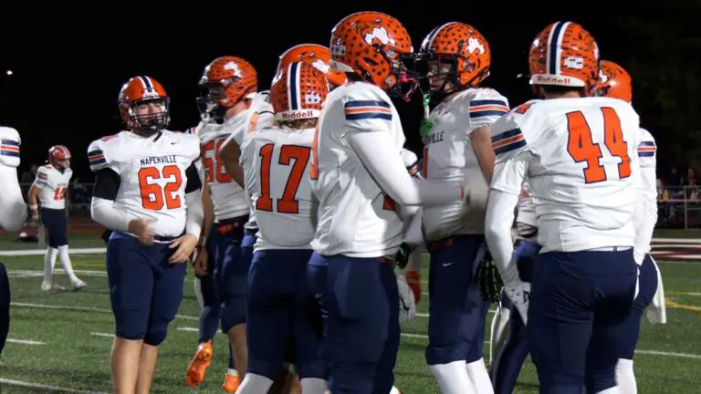 Naperville North football wins and they are huddled up