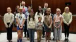 Naperville area private school students who contributed to Crime Prevention Calendar stand with mayor and police chief