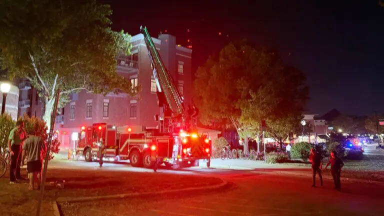 A fire truck near the building with its ladder deployed