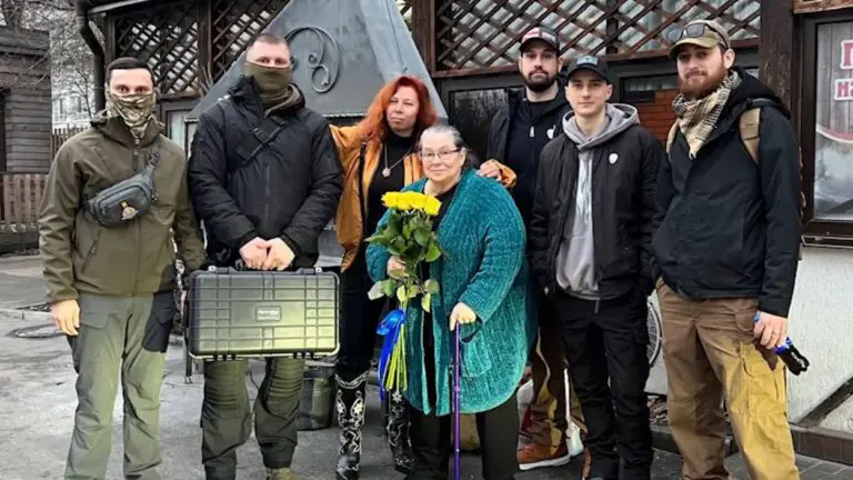 Naperville resident Ausra Tallat-Kelpsa Di Raimondo holding flowers and standing with group in Ukraine