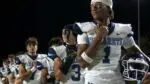 Nazareth Academy handily defeats Benet Academy as players stand and look on.