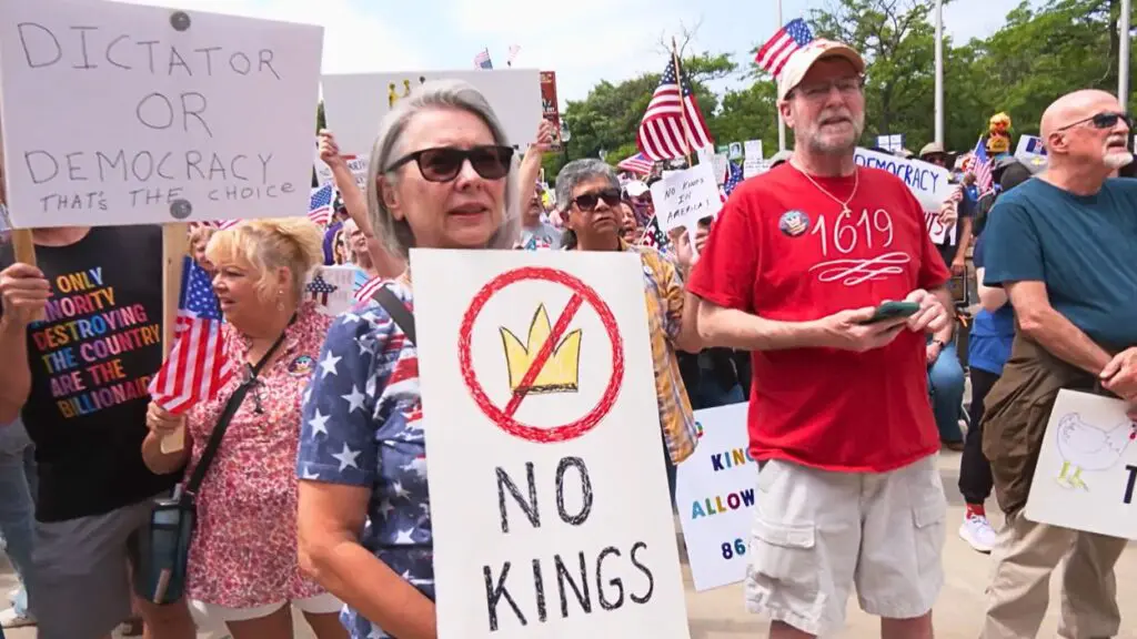 Rally goers at No Kings Rally with one woman holding a No Kings sign