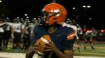 Naperville North stifles Lincoln-Way East as a player holds the ball during warmups.