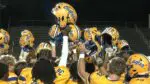 Sandburg football knocks Neuqua Valley back and the team holds up their helmets post game.
