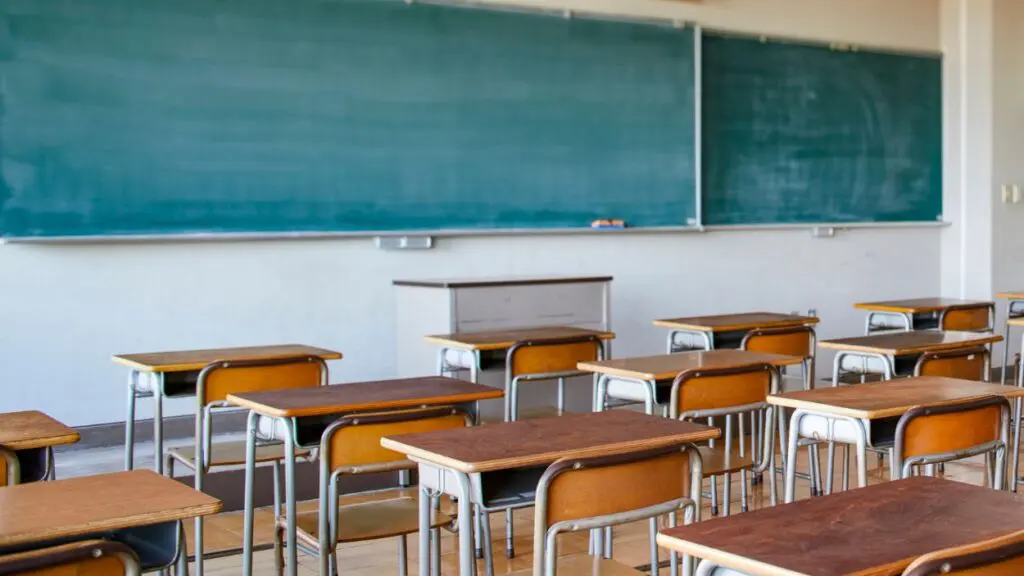 Empty classroom with desks and blackboard visible