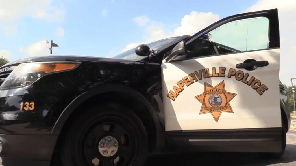 Close up side of Naperville police car with open driver side door with logo visible