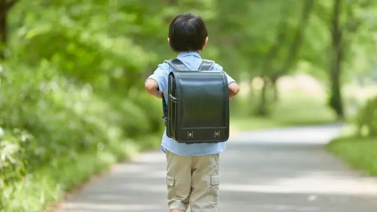 Boy walking with backpack down a path