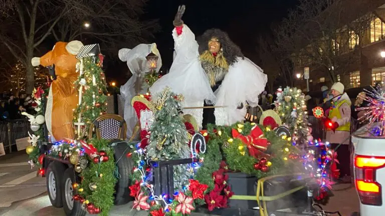 A woman waves from a parade float at the 2025 Holiday Parade of Lights in downtown Naperville.