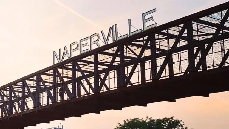 Naperville sign on top of pedestrian walkway with sunset in background for 6 things to know about Naperville in 2026 story