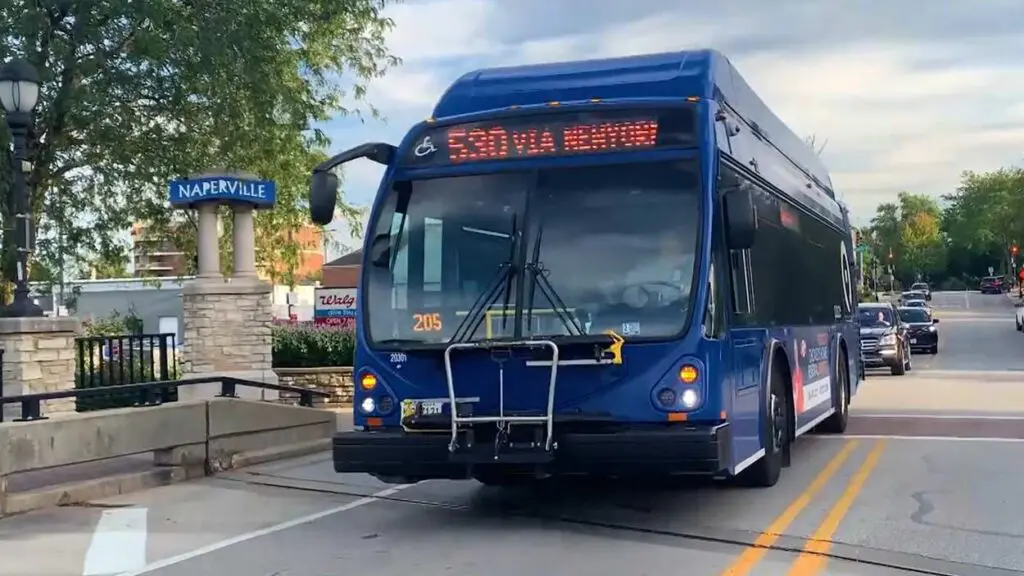 PACE bus on street next to Naperville sign