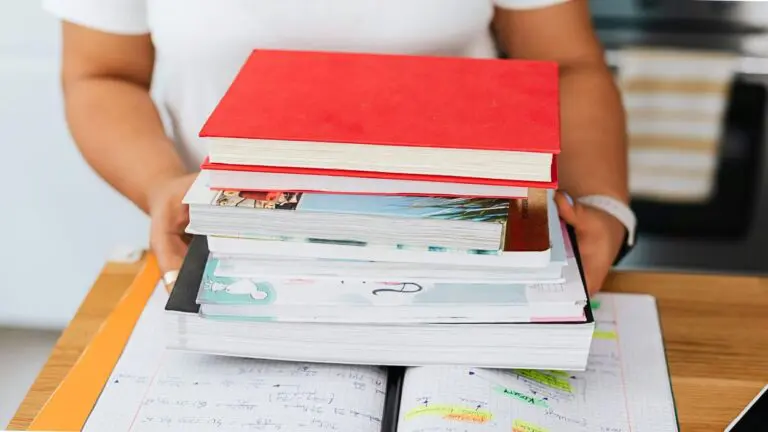 Close up of stack of books and notebooks held by student