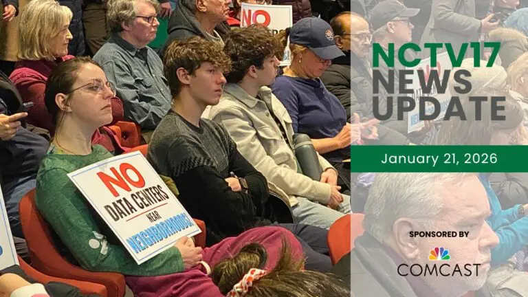 Community members sit at a Naperville city council meeting to discuss a a data center proposal, with one person holding a sign that reads "No Data Center near Neighborhoods."