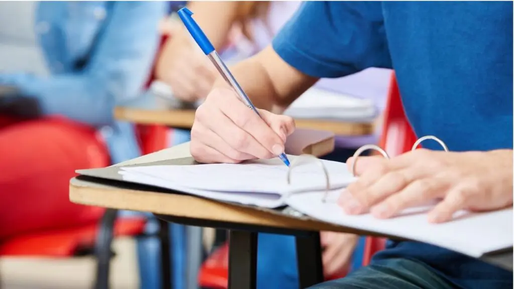 Close up of student in class with pen and notebook