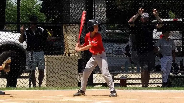 A Naperville Little League Baseball player in a red jersey is at bat.