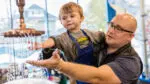 A father and son explore a water feature at DuPage Children's Museum.