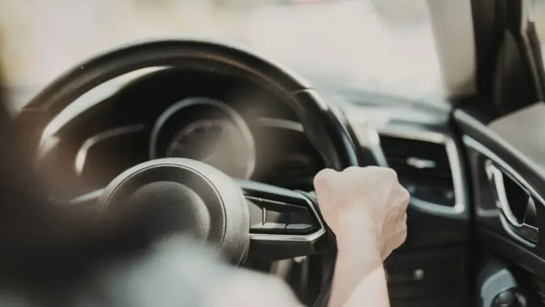 Close up of hands on steering wheel in a car