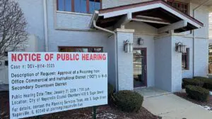 public hearing sign in front of building for proposed condo development