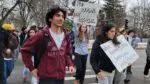 Naperville North students walk out holding signs in protest for ICE.