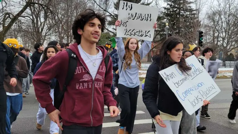 Naperville North students walk out holding signs in protest for ICE.