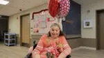 A DuPage Care Center resident smiles after her Valentine's Day balloon delivery.