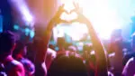Hands create a heart at a concert.