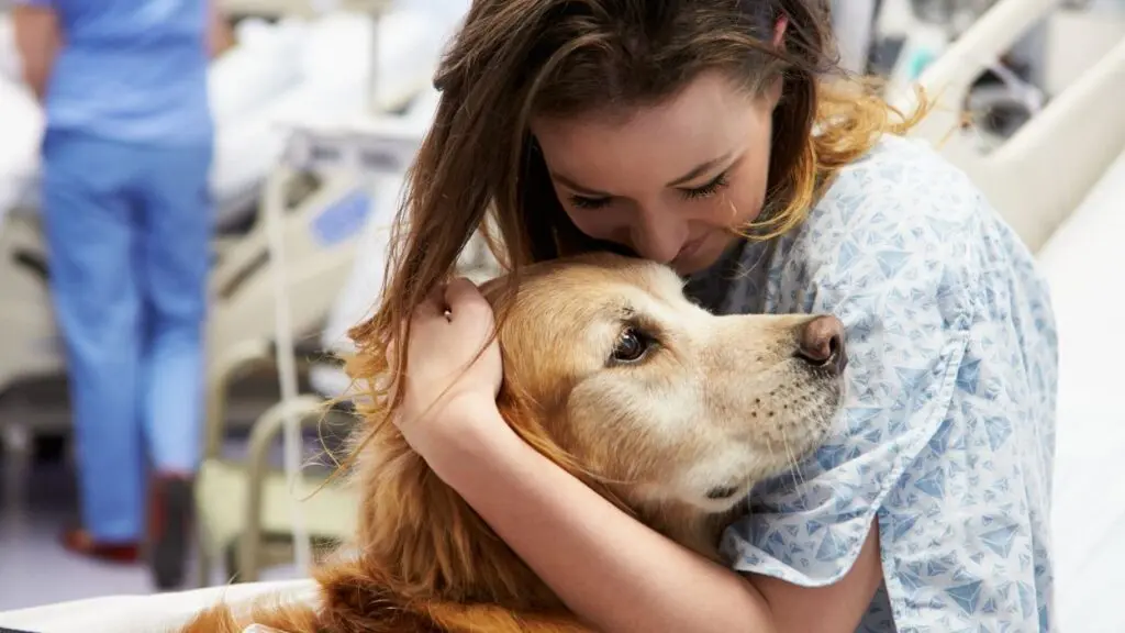 woman hugs a therapy dog at hospital