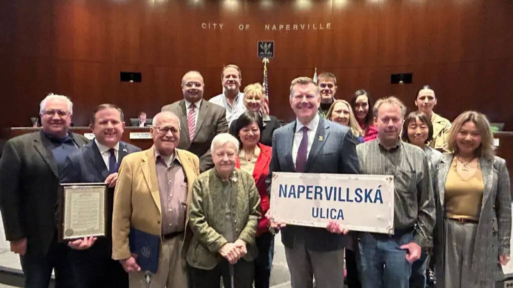 Naperville mayor and group of others gathered around longtime civic leader Rosemary Macko Wisnosky holding Nitra Naperville sign
