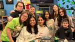 Naperville teens Srestha Mithra, Lahari Gonuguntla, and Srishti Garg, founders of Crafting with Community, pose for a picture with guests at Gigi's Playhouse.