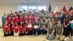 Students in the veterans clubs at Naperville North and Naperville Central High Schools smile for a group picture as they receive the KidsMatter Make Kindness Count Award.