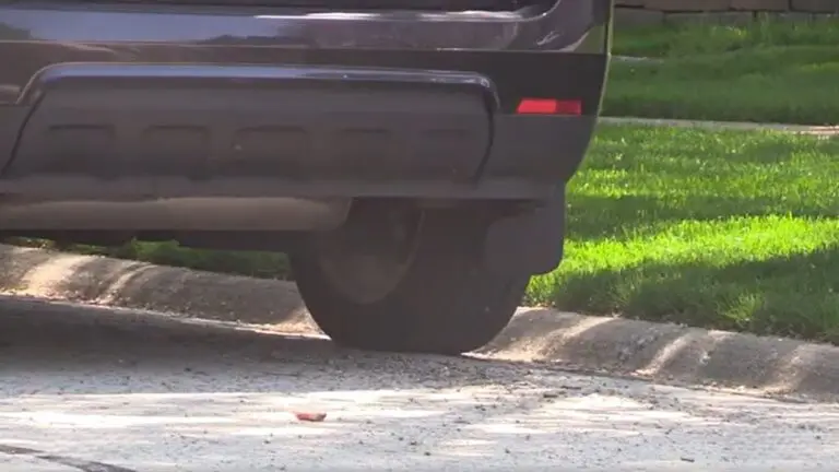 Close up of wheel and back of car parked on side of street