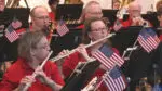 Flute players from the Naperville Municipal Band perform on stage during their patriotic concert.