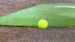 A softball sits near the pitching mound.