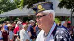 A member of the American Legion Post 43 in the Naperville Memorial Day Parade with the crowd in the background.