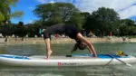a woman bending backwards on a paddleboard for yoga on the water in Naperville