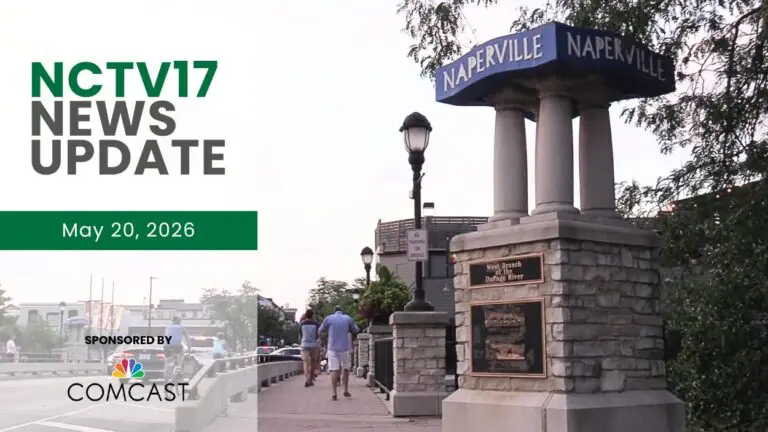A shot of the blue Naperville sign in downtown Naperville with people walking on a nearby sidewalk.