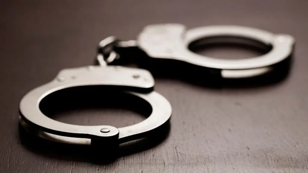 A close up picture of handcuffs on a table for a story on how a DuPage County deputy has been charged with disseminating child sexual abuse material.