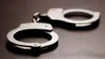 A close up picture of handcuffs on a table for a story on how a DuPage County deputy has been charged with disseminating child sexual abuse material.