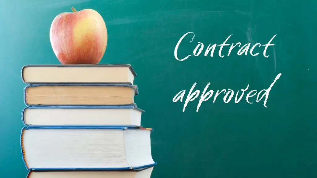 pile of books with apple on top with chalkboard in the background with the words Contract approved written on board