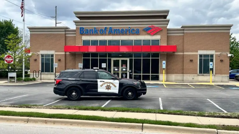 The exterior of a Naperville Bank of America, which was hit with a robbery, with Naperville Police Department car parked in front of the building.