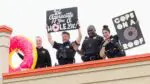Naperville Police hold signs and smile for a picture on the roof of Dunkin in Naperville as they took part in the Cop on a Rooftop fundraiser.