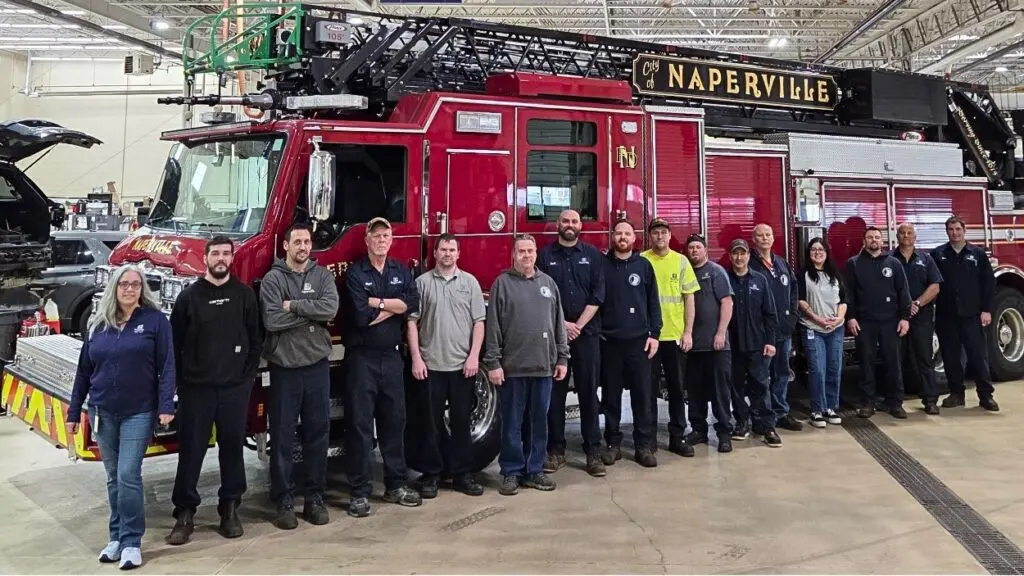 Members of Naperville's fleet services team smile for a picture in front of a fire truck.