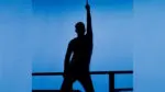 A silhouette of a Summer Place Theatre performer with his right hand raised up over a blue background.