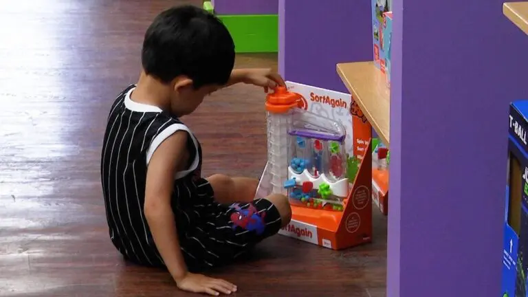 A child is sat on the floor and playing with a toy at Anderson's Toyshop in Naperville.