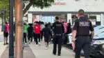 Police officers walk behind group of teens in downtown Naperville
