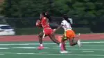 One girl chases another girl in a game of flag football.